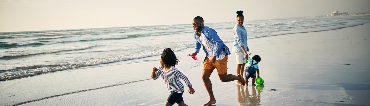 Shot of a young family spending time together at the beach